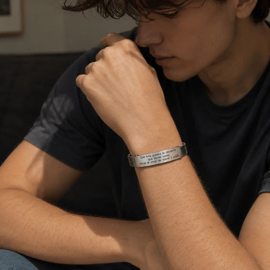 Brazalete esclava de malla Moment en acero inoxidable con frase grabada personalizada en la muñeca de un joven