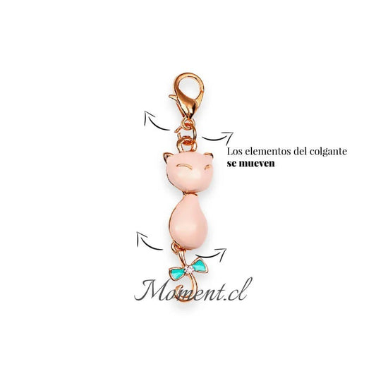 Colgante Moment con forma de gato dorado, cuerpo esmaltado en rosa y lazo turquesa con detalle de cristal brillante.