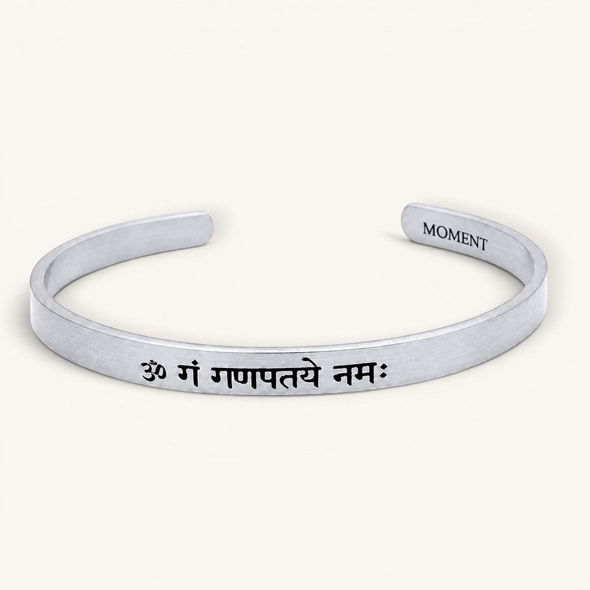 Brazalete esclava Moment de acero inoxidable con grabado personalizado en sánscrito y acabado mate minimalista.