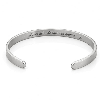 Brazalete esclava Moment de acero inoxidable con grabado personalizado en el interior sobre fondo blanco.
