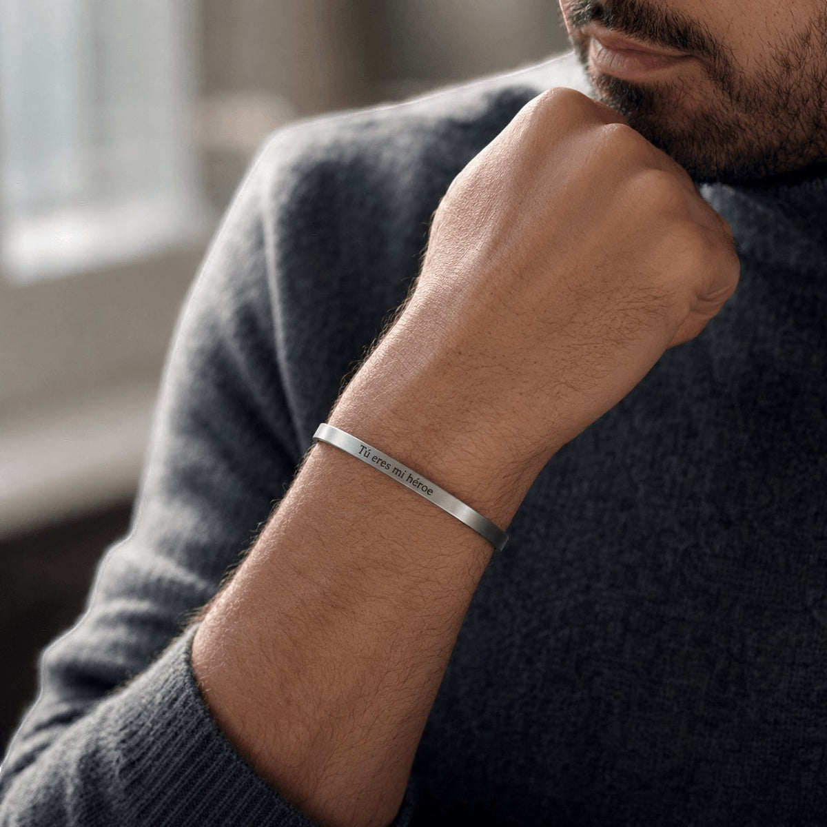 Brazalete esclava Moment de acero inoxidable ajustable con grabado personalizado en la muñeca de un hombre.