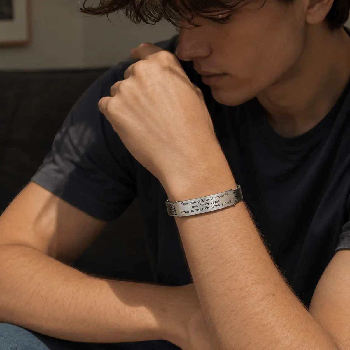 Brazalete esclava de malla Moment en acero inoxidable con frase grabada personalizada en la muñeca de un joven