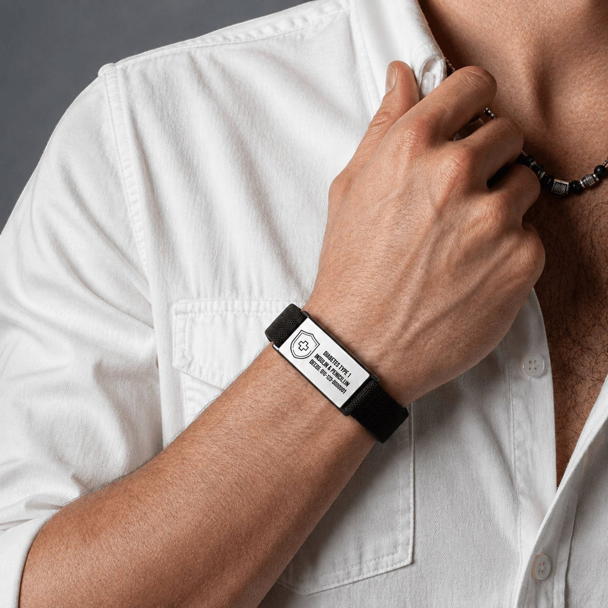 Brazalete Flex personalizado de Moment con placa de acero inoxidable y cordón elástico negro en la muñeca de un hombre