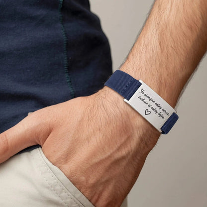 Brazalete Flex personalizado Moment con placa de acero inoxidable y cordón elástico azul en la muñeca de un hombre