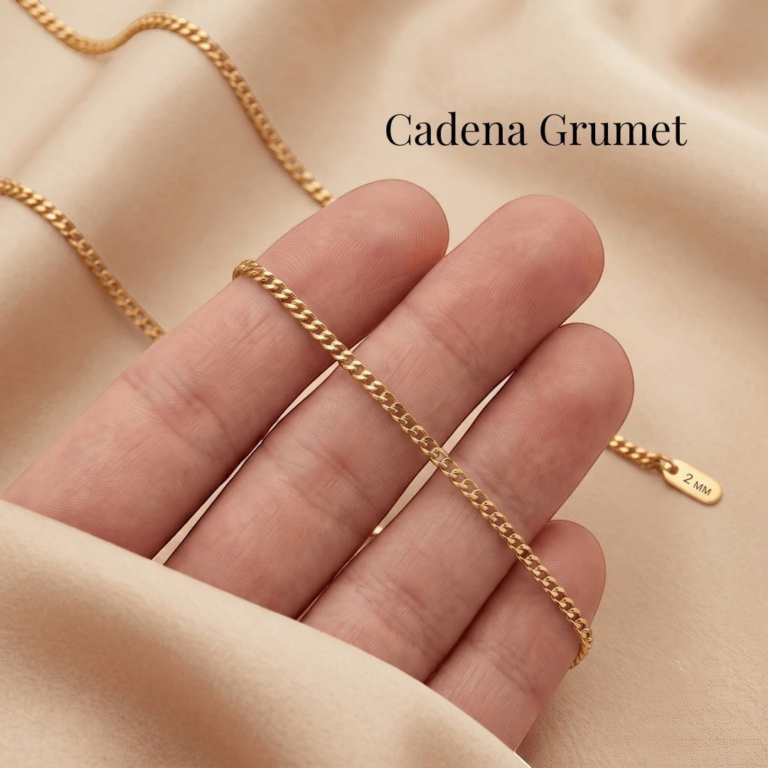 Cadena grumet dorada de acero quirúrgico de Moment sobre fondo de tela suave