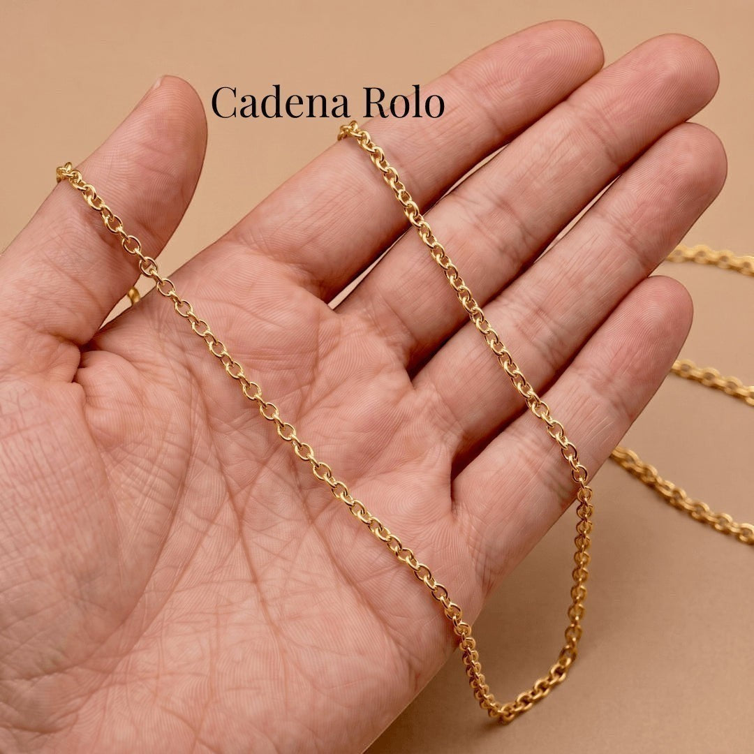 Cadena rolo dorada de acero quirúrgico Moment sostenida en la mano, ideal para medallón personalizable.