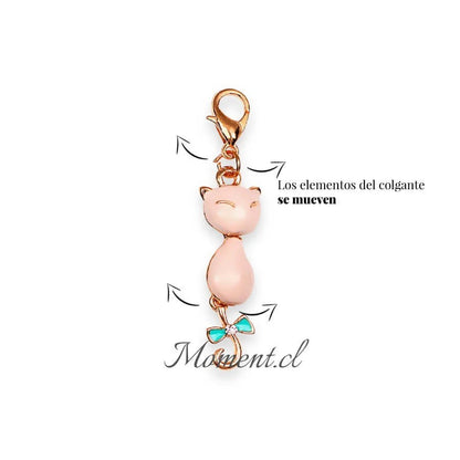 Colgante Moment con forma de gato dorado, cuerpo esmaltado en rosa y lazo turquesa con detalle de cristal brillante.