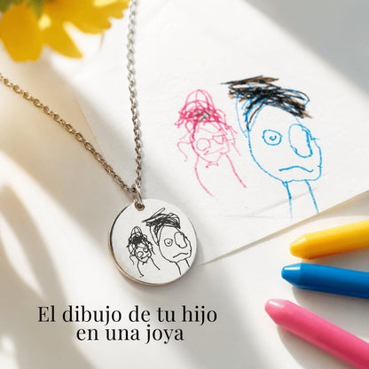 Collar Moment de acero inoxidable plateado con medalla grabada con un dibujo infantil junto a ceras de colores
