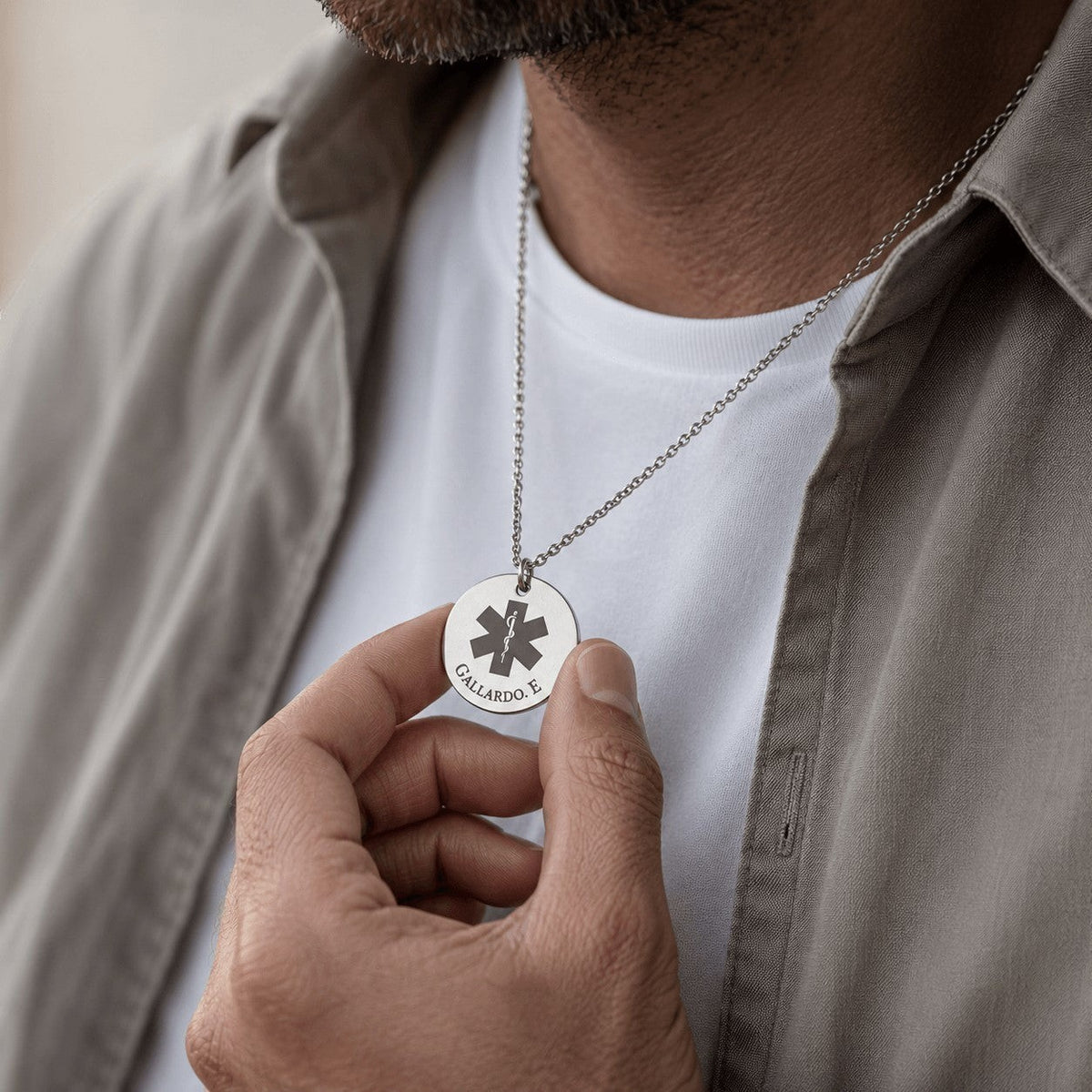 Collar Moment de acero inoxidable plateado con medalla redonda personalizada y grabado médico en el cuello de un hombre