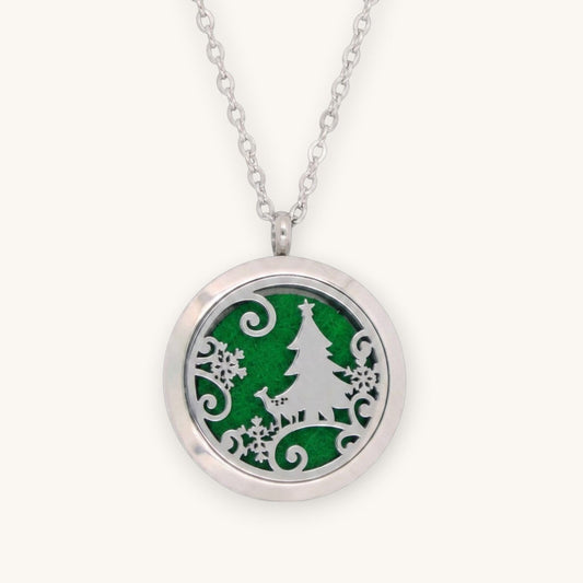 Collar Moment de acero inoxidable con medallón difusor redondo y diseño de árbol de navidad sobre fieltro verde