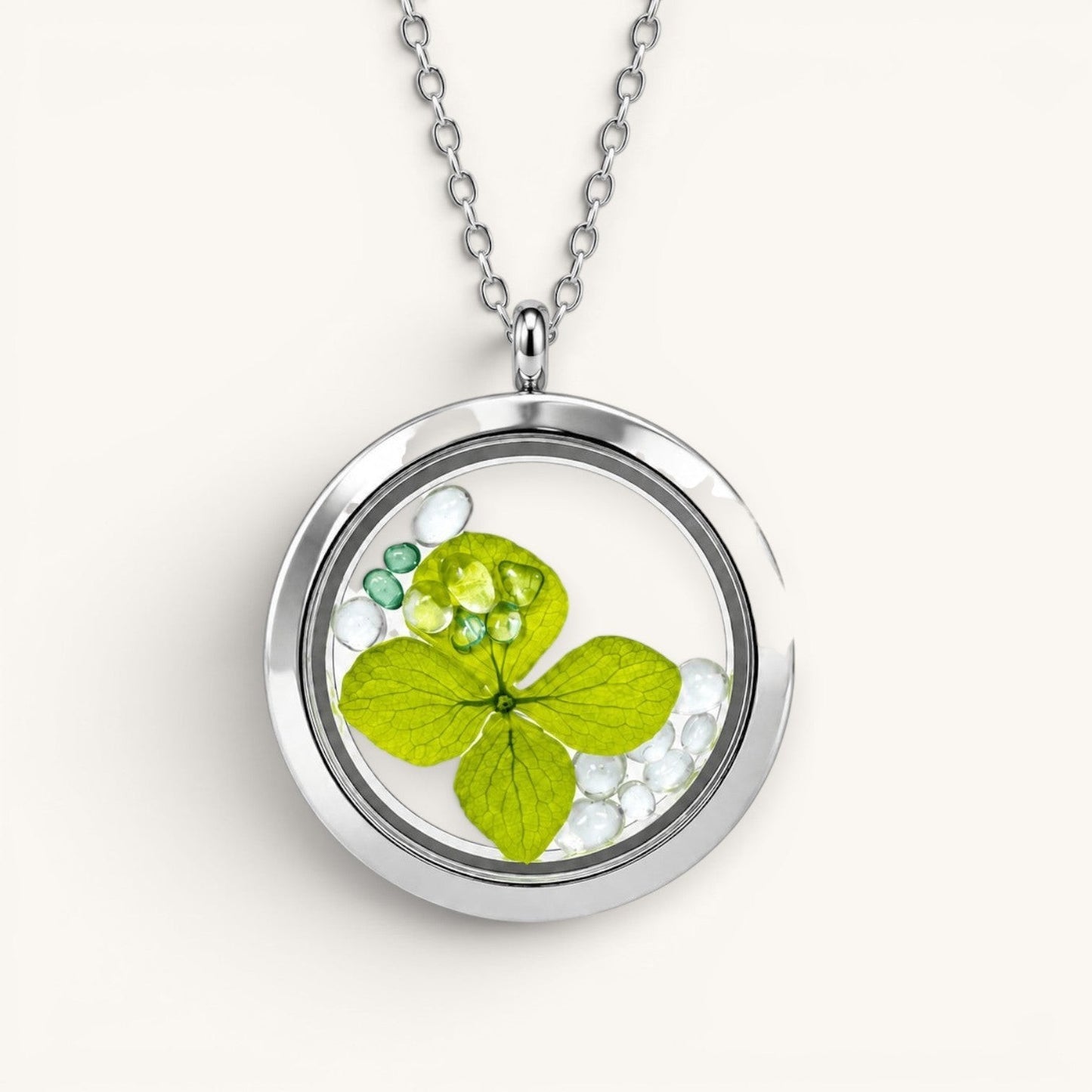Collar Moment con medallón de acero quirúrgico y vidrio que contiene una hoja verde y minigemas decorativas