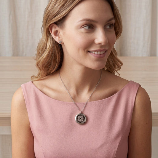 Mujer luciendo collar Moment de acero quirúrgico con medallón redondo estilo arabesco para aromaterapia
