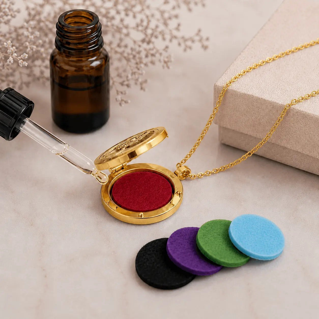 Collar Moment de acero dorado con medallón aromaterapia abierto, disco de fieltro rojo y set de repuestos de colores.