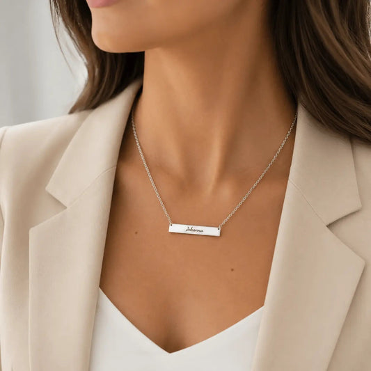 Collar Moment con placa rectangular de acero inoxidable personalizada con nombre, lucido por una mujer con blazer