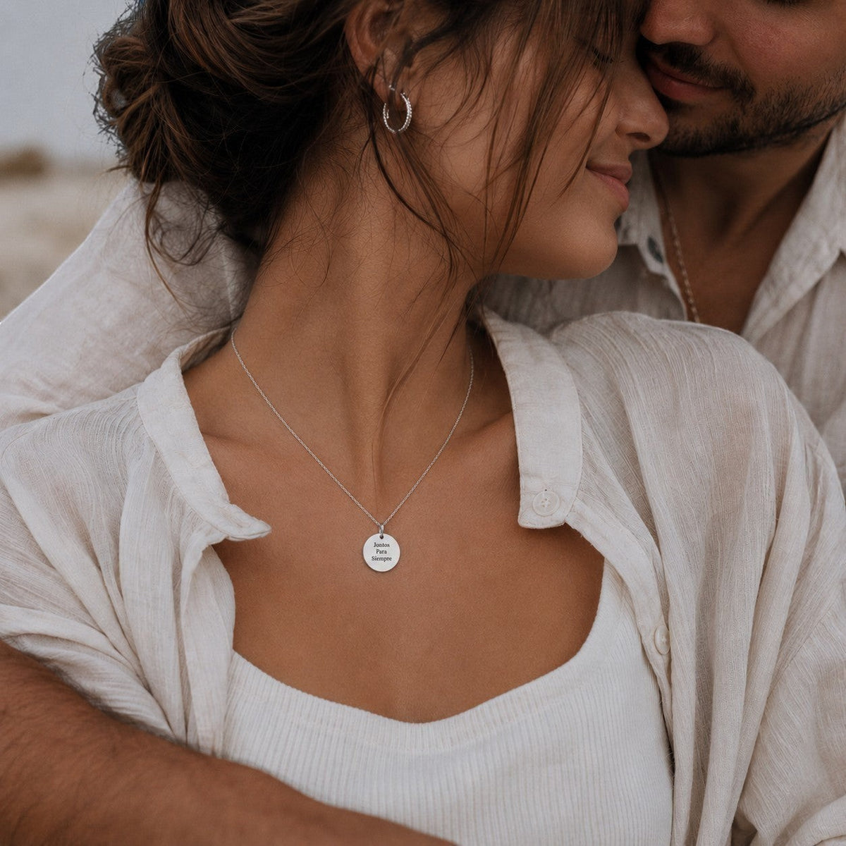 Collar Moment de plata con medalla redonda personalizada grabado con texto, lucido por una mujer en un abrazo romántico