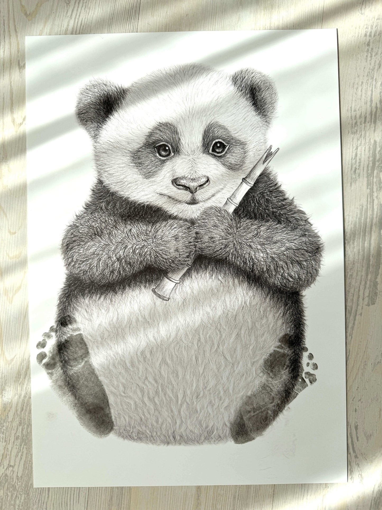 Ilustración artística en blanco y negro de un tierno oso panda con bambú, parte del kit Mis primeras huellas Moment