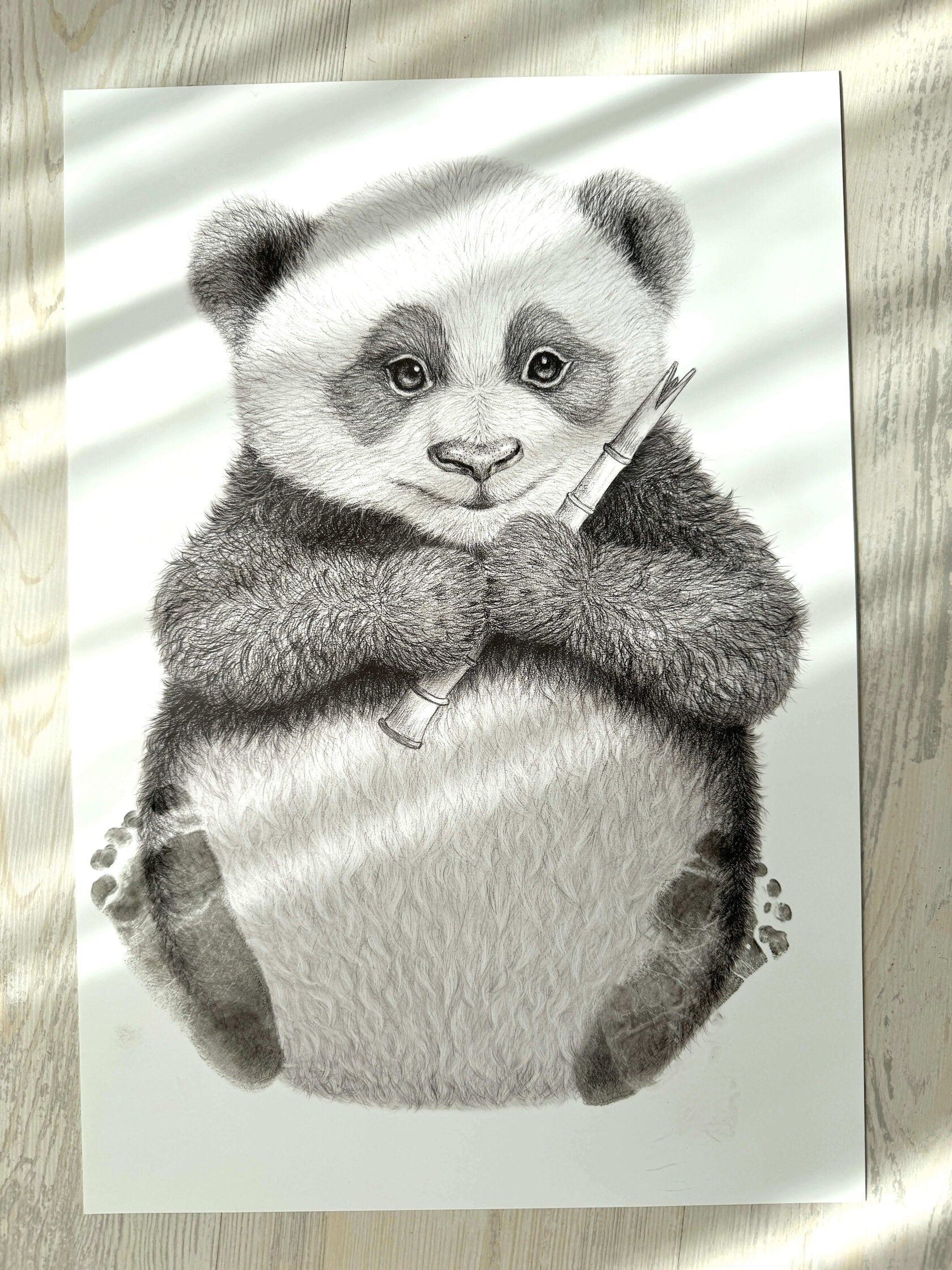 Ilustración artística en blanco y negro de un tierno oso panda con bambú, parte del kit Mis primeras huellas Moment