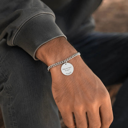 Pulsera cubana Moment de acero inoxidable con medalla redonda personalizada grabada en la muñeca de un hombre.