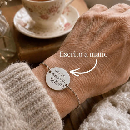 Pulsera Moment de acero inoxidable con medalla personalizada grabada con mensaje escrito a mano en una muñeca