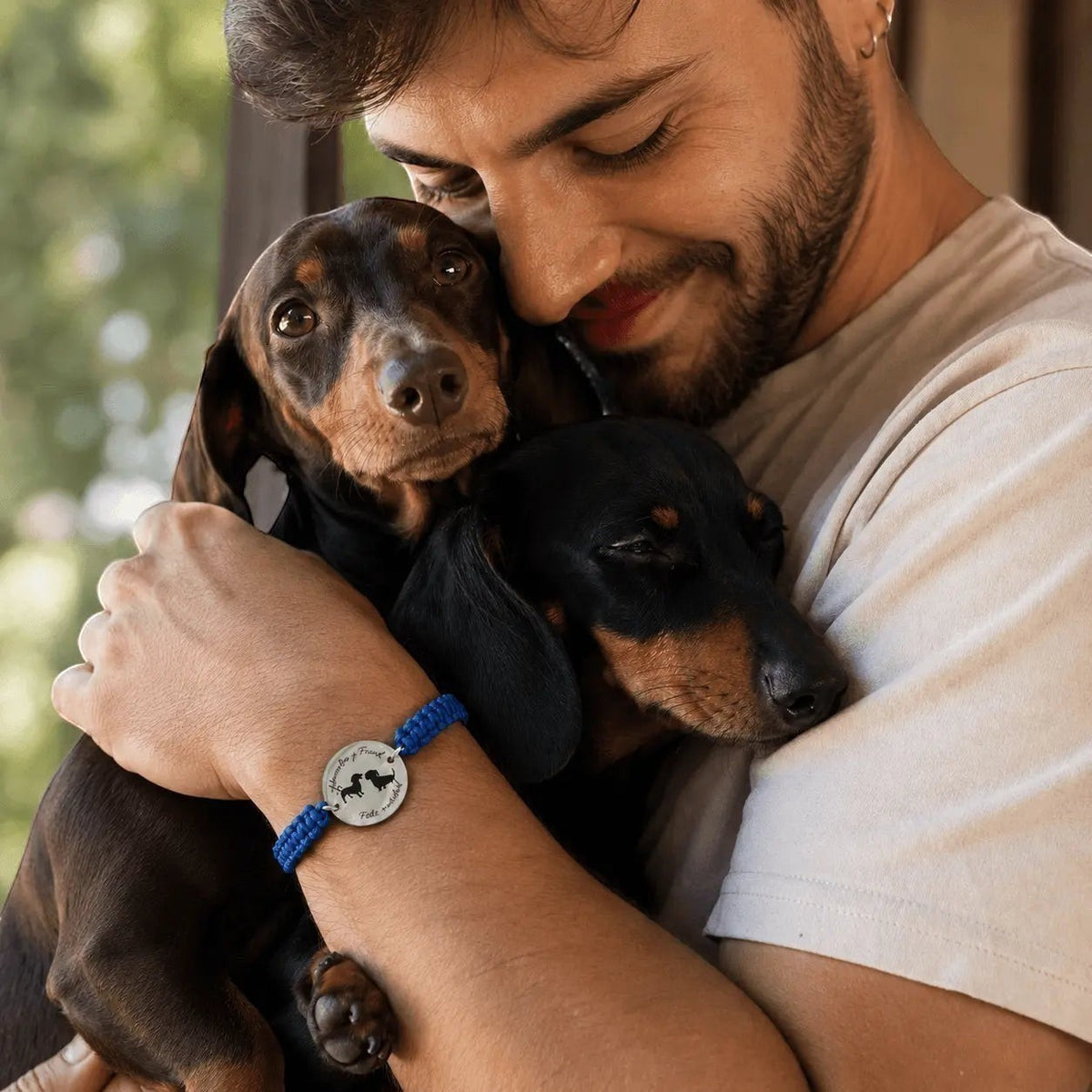 Pulsera Nudo Personalizada Moment con medalla grabada de perros, cordón azul ajustable, usada por un hombre con perros