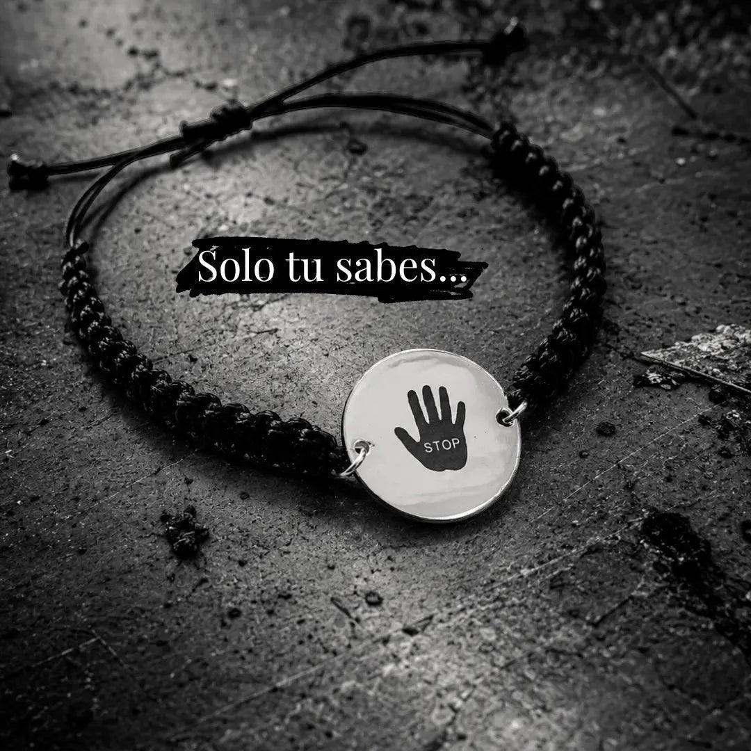 Pulsera Moment de cordón negro ajustable con medalla redonda de plata grabada con una mano y la palabra STOP