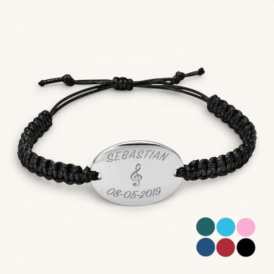 Pulsera Moment con placa ovalada de acero inoxidable y cordón negro ajustable, personalizada con nombre y fecha.
