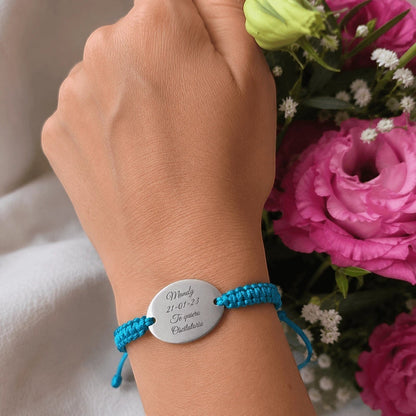 Pulsera Moment con placa ovalada de acero inoxidable y cordón azul ajustable, personalizada con grabado de texto.