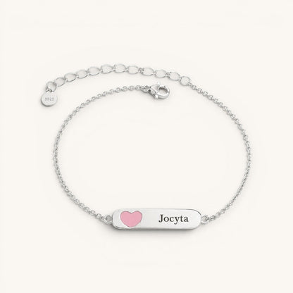 Pulsera Moment de plata para niña con placa grabada y detalle de corazón rosado, diseño ajustable y delicado